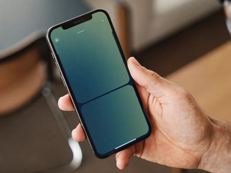 Mano sosteniendo un teléfono con una interfaz financiera